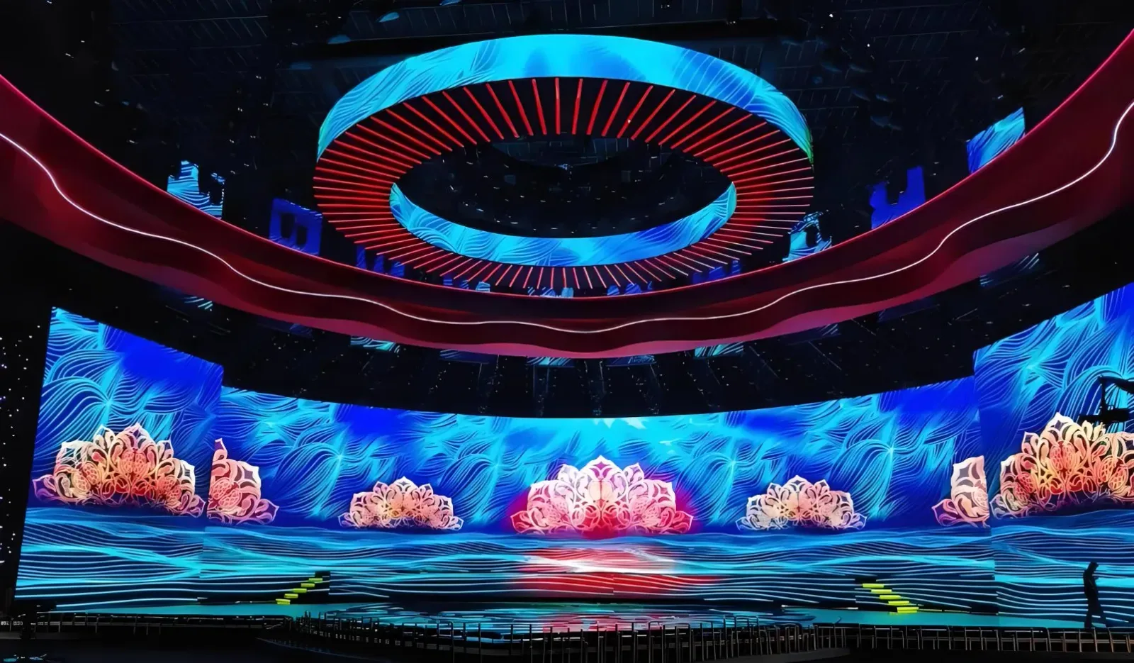 Immersive LED stage installation with a curved video wall and a suspended circular screen